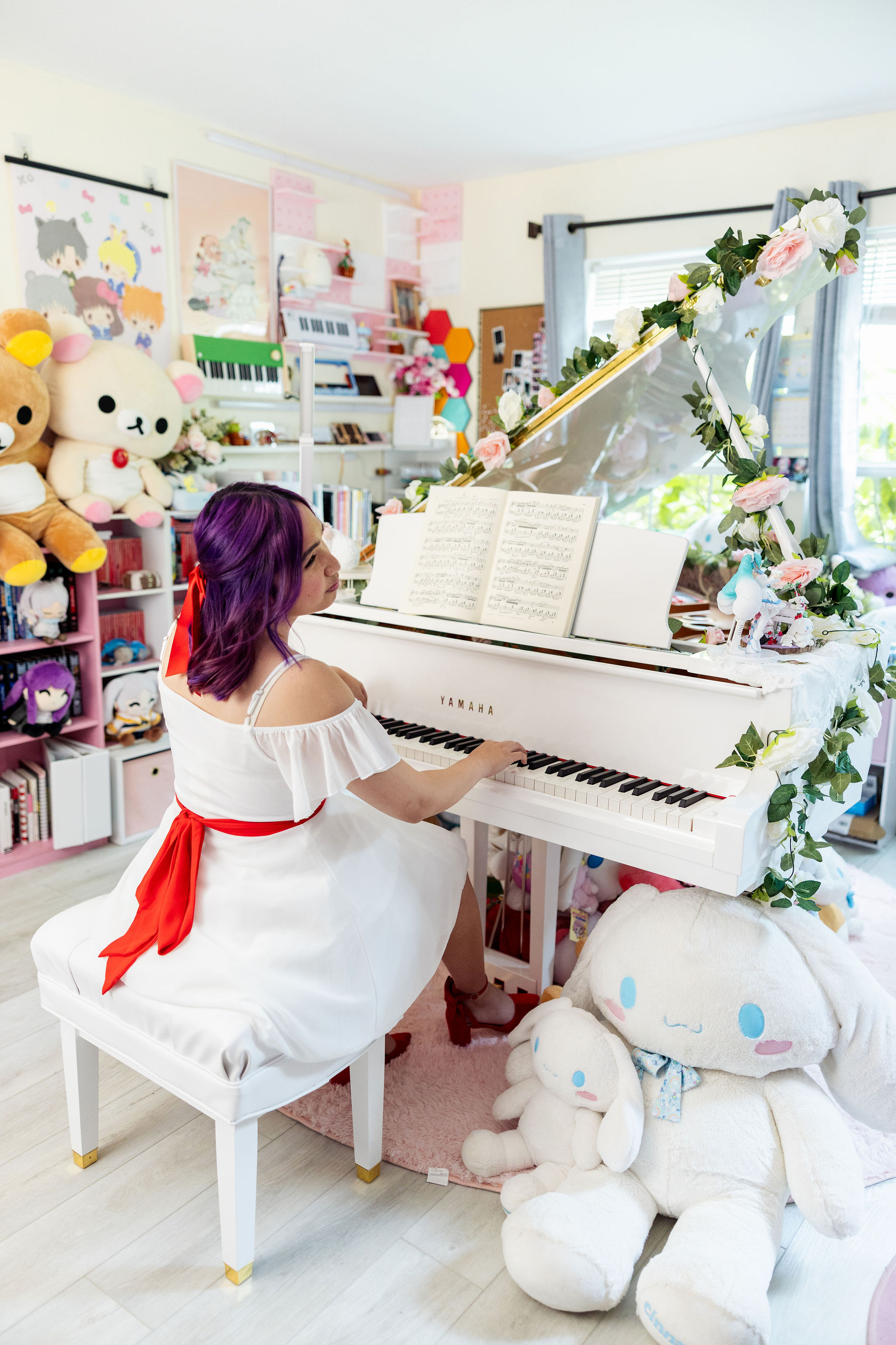 Playing the grand piano surrounded by Cinnamoroll plushies