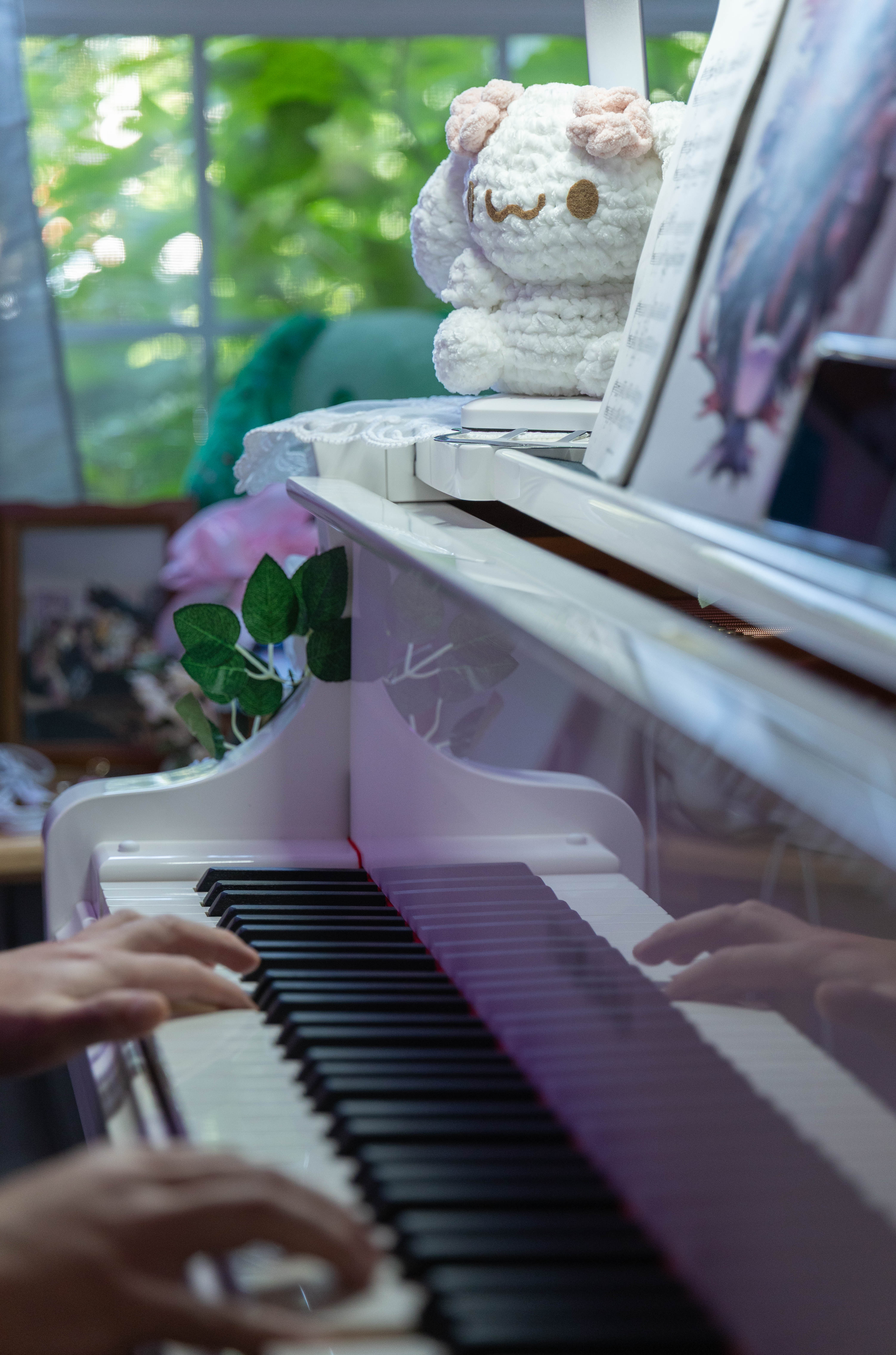 Playing piano with a crochet Cinnamoroll plushie on top